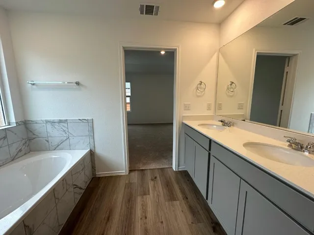 a spacious bathroom with a double vanity sink and mirror