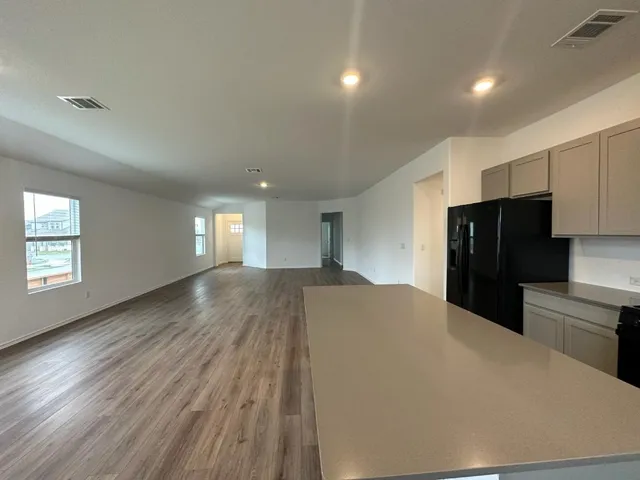 a kitchen with granite countertop a refrigerator and a stove top oven