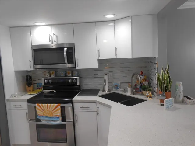a kitchen that has a sink and a stove in it
