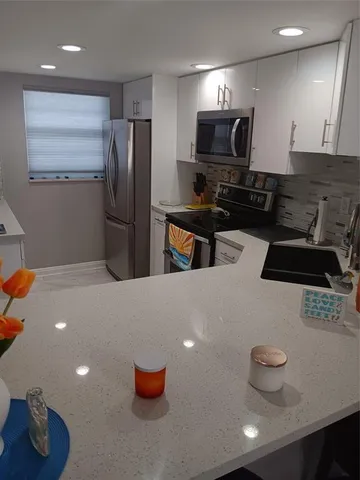 a kitchen with stainless steel appliances a refrigerator and a stove