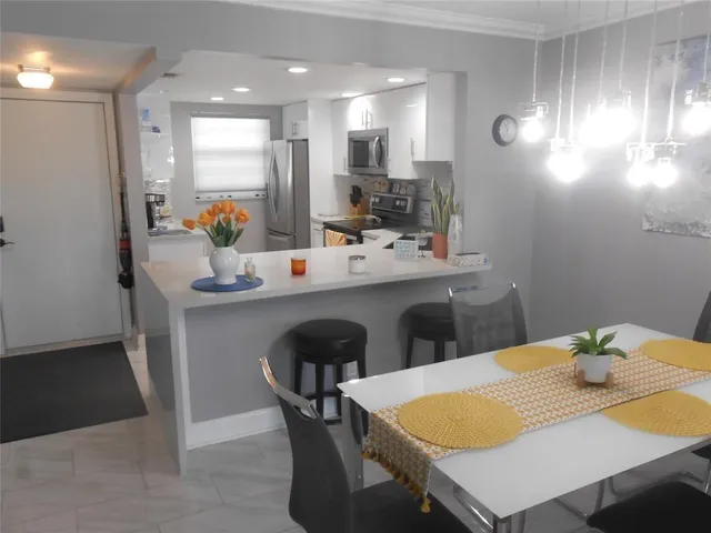 a kitchen with a table chairs and a refrigerator