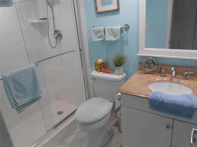 a bathroom with a granite countertop sink toilet and shower
