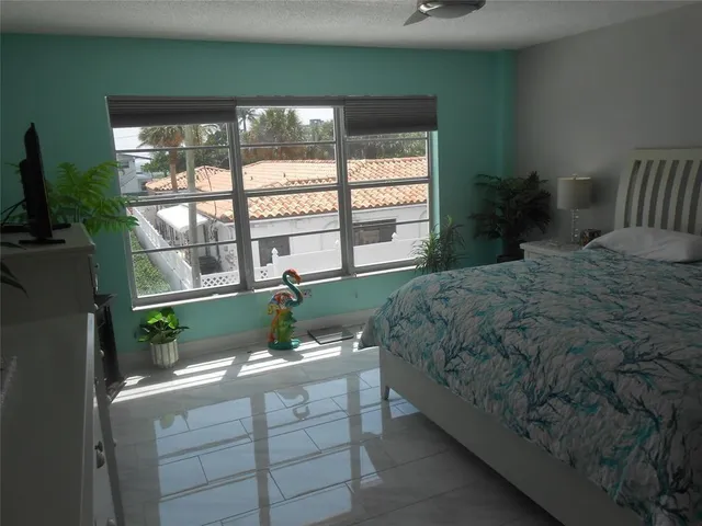 a bedroom with a bed and a large window