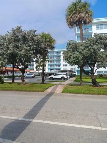 a view of green field with palm trees