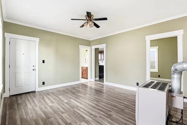 a view of a room with wooden floor and a ceiling fan