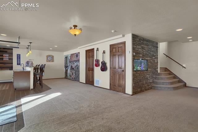 965 Bowstring Road Monument, CO 80132 - Photo 31 of 34 Stairs leading to the lower level. The built-in fish tank stays.