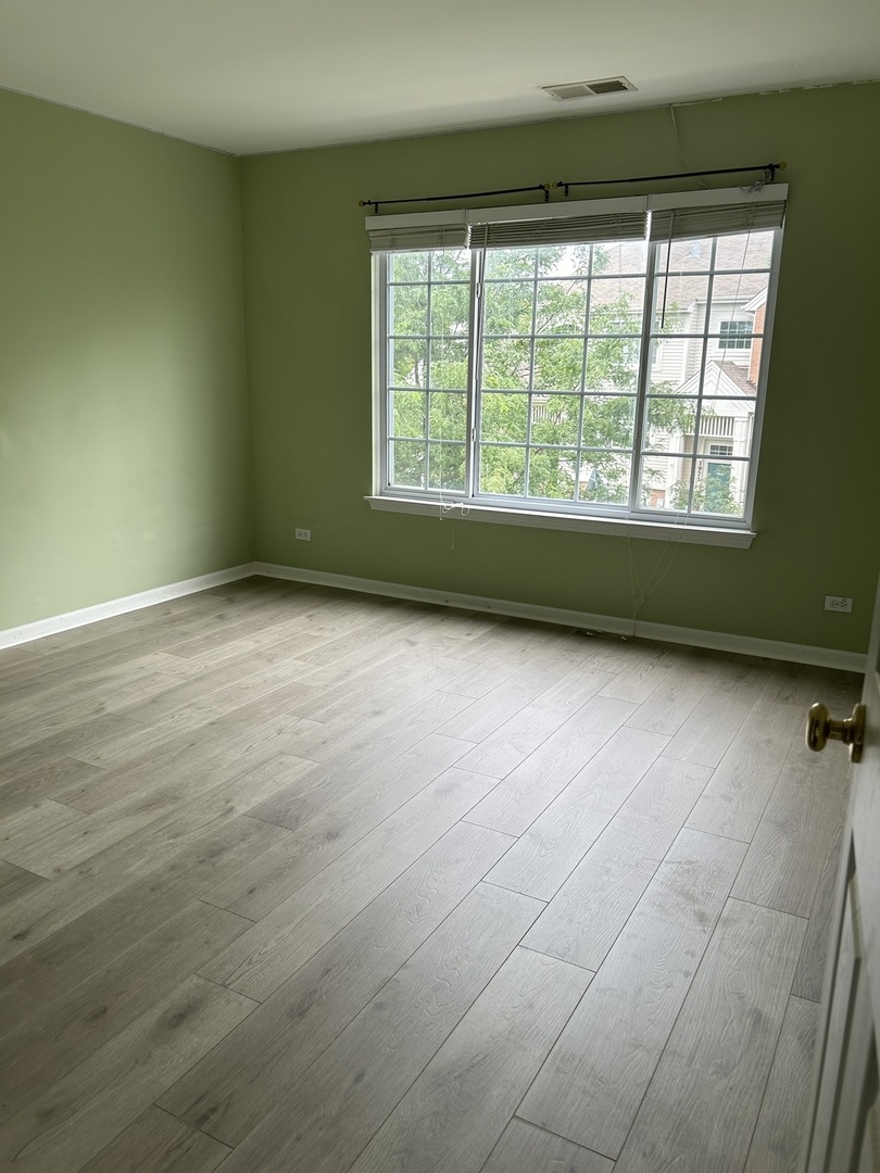 2005 Concord Drive McHenry, IL 60050 - Photo 7 of 12 a view of an empty room with a window and wooden floor