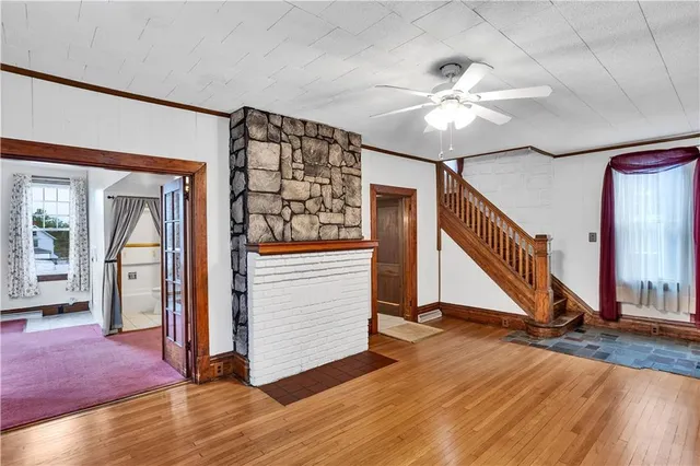 a view of a livingroom with wooden floor and stairs