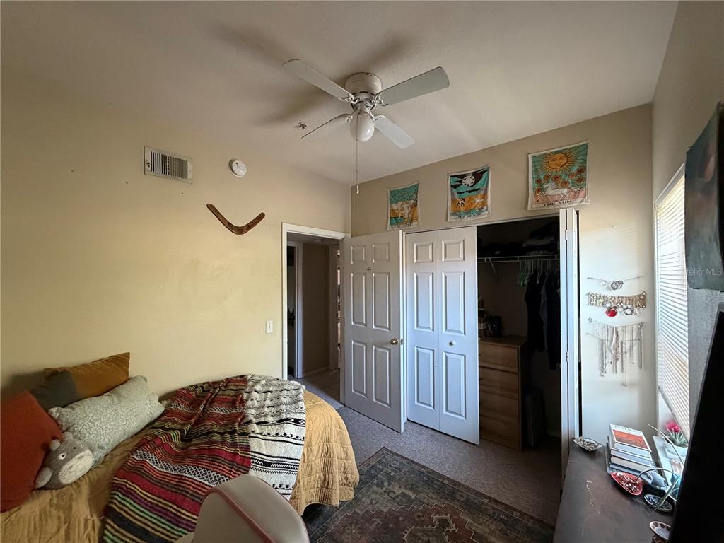 10764 70th Avenue, Unit 2301 Seminole, FL 33772 - Photo 18 of 19 a bedroom with a bed and a chandelier