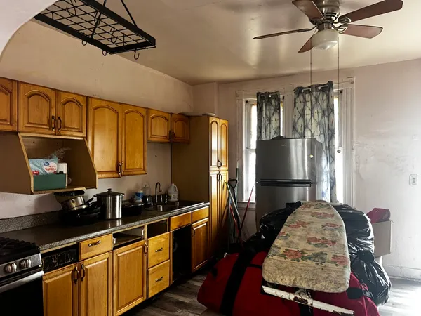 a kitchen with stainless steel appliances granite countertop a refrigerator a stove and a sink with wooden floor
