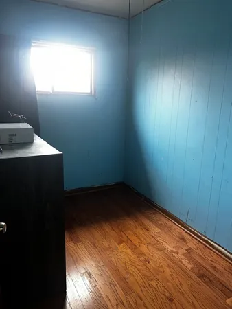 a view of empty room with wooden floor