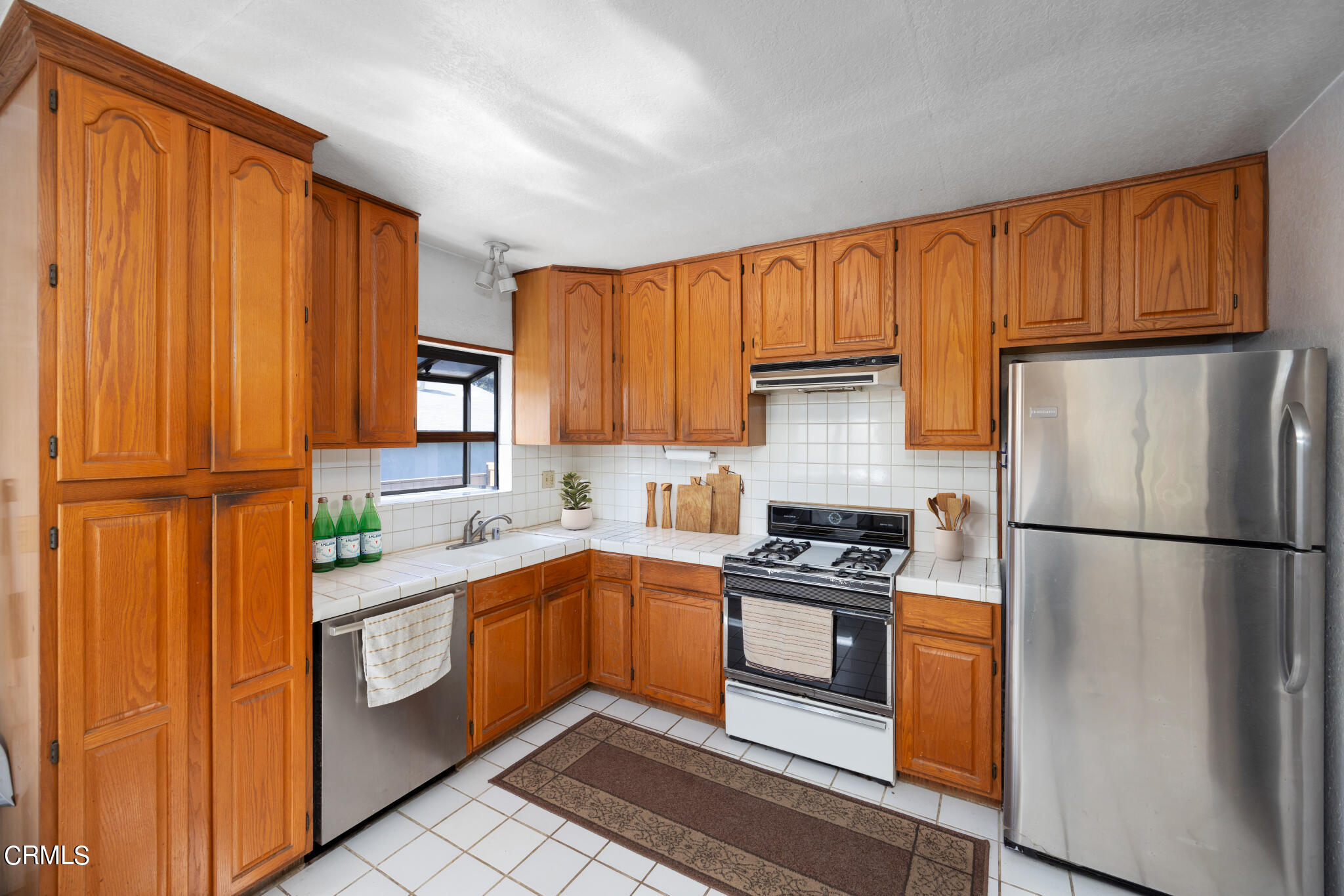 768 Atchison Street Pasadena, CA 91104 - Photo 7 of 23 a kitchen with granite countertop stainless steel appliances a refrigerator sink and cabinets
