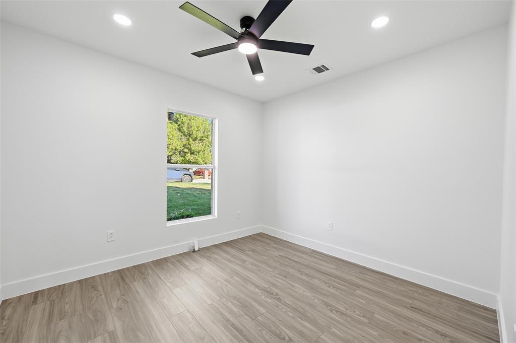 2618 Gooch Street Dallas, TX 75241 - Photo 16 of 28 an empty room with wooden floor chandelier fan and windows