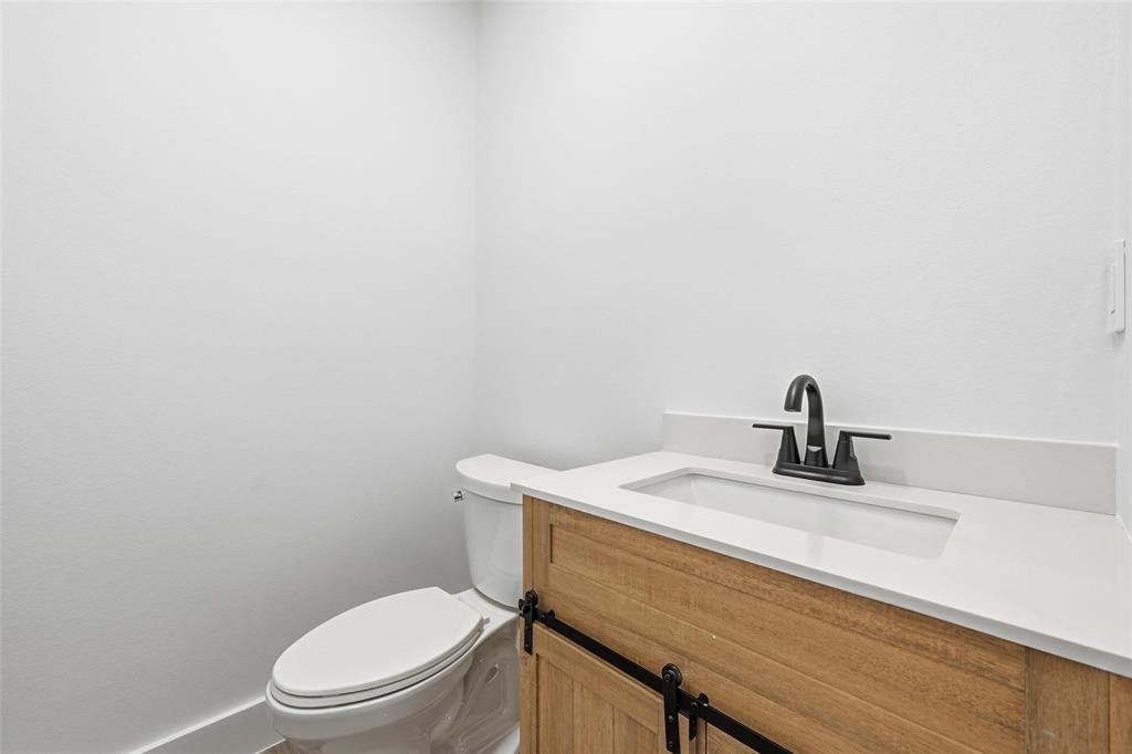 2618 Gooch Street Dallas, TX 75241 - Photo 21 of 28 a bathroom with a toilet a sink and mirror
