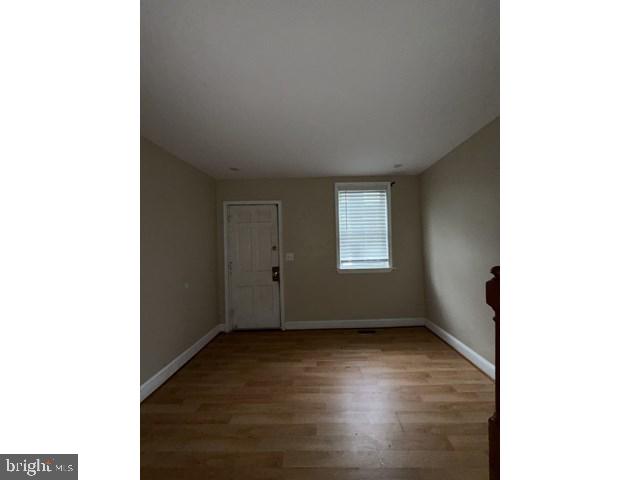 1611 Lemmon Street Baltimore, MD 21223 - Photo 4 of 20 a view of an empty room with wooden floor and a window