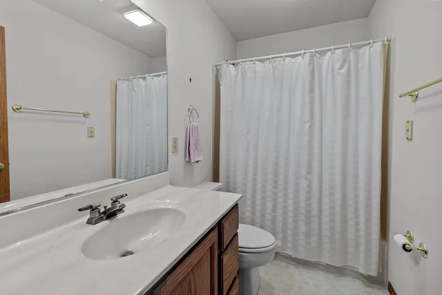 a bathroom with a sink a toilet and shower curtain
