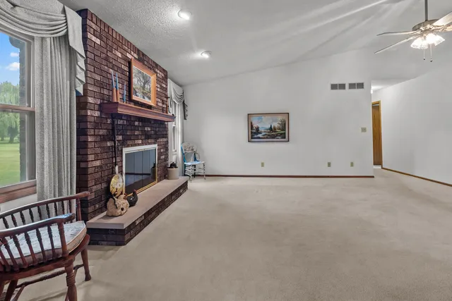 a view of an empty room with a fireplace and a window