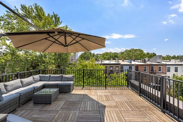 a view of a balcony with furniture and umbrella