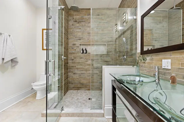 a bathroom with a granite countertop sink a toilet and shower
