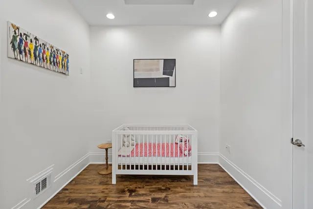 a room with a white wall and a painting on the wall