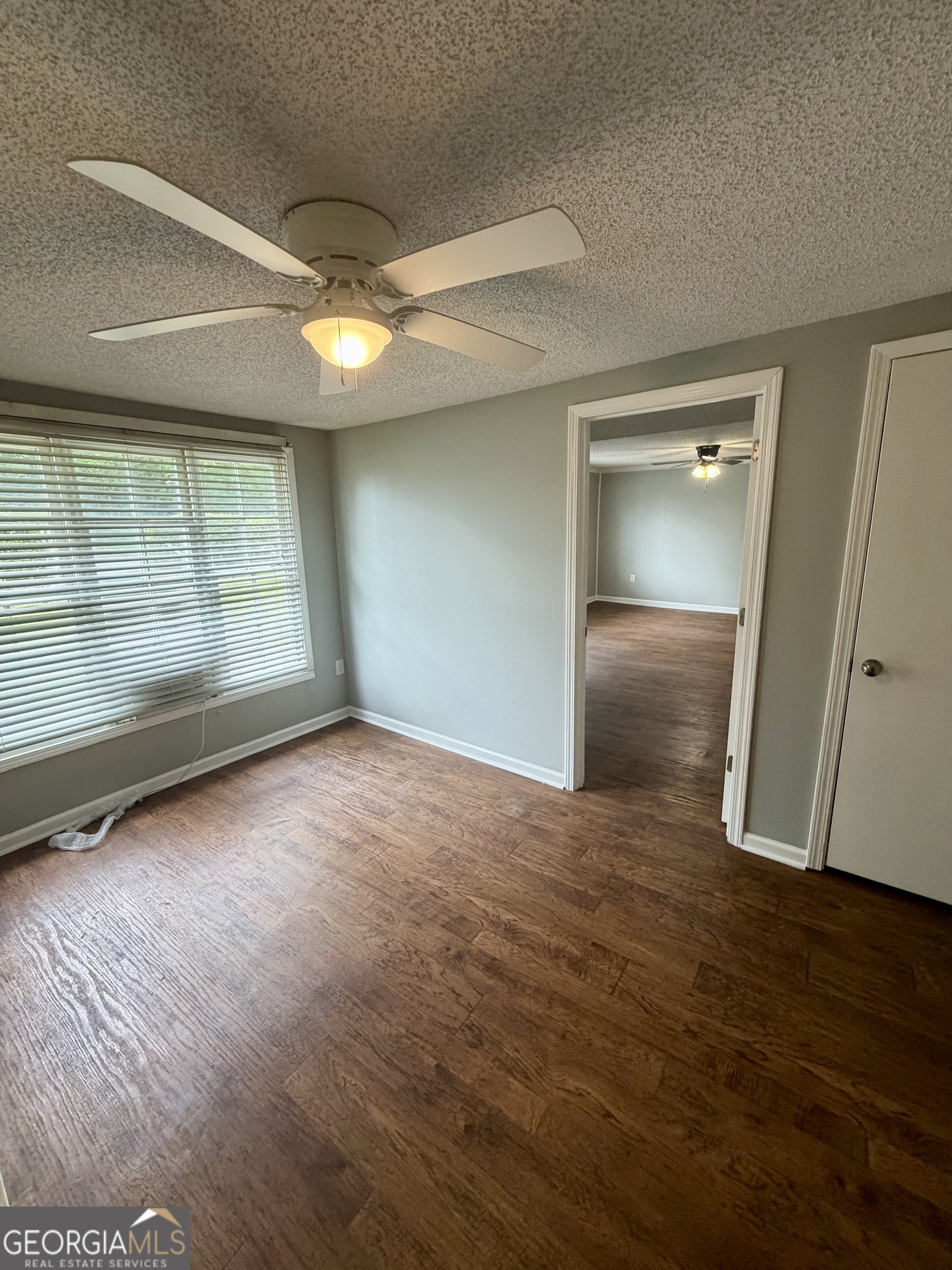 666 Woolfolk Street Macon, GA 31217 - Photo 14 of 60 an empty room with wooden floor and door