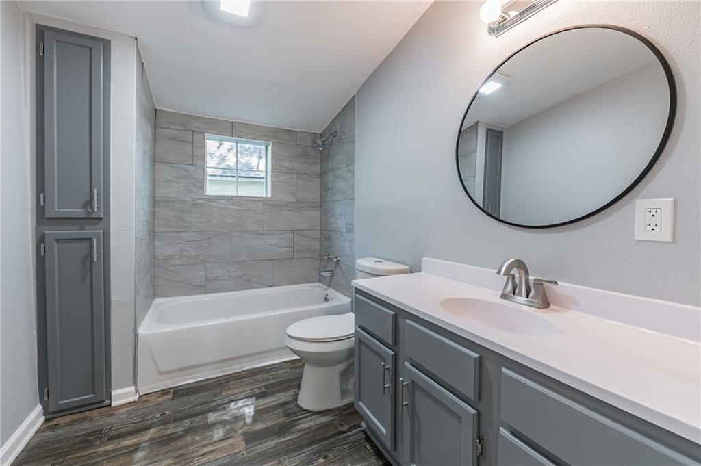1002 South 2nd Street Temple, TX 76504 - Photo 7 of 10 a bathroom with a sink a toilet and a mirror