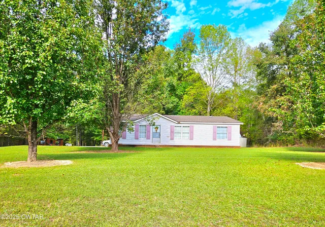 a view of a house with a yard and a tree