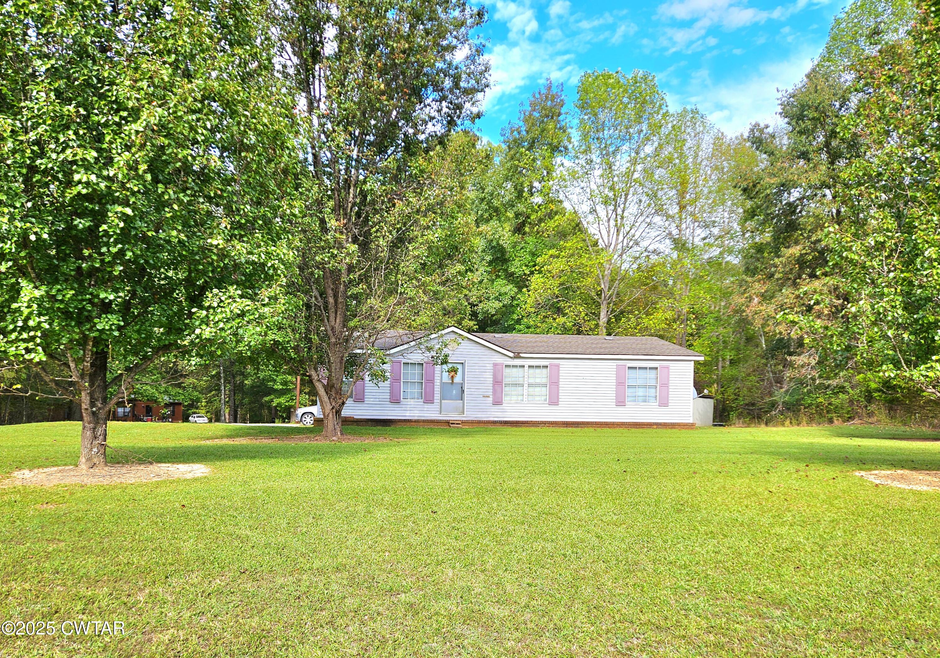a view of a house with a yard and a tree
