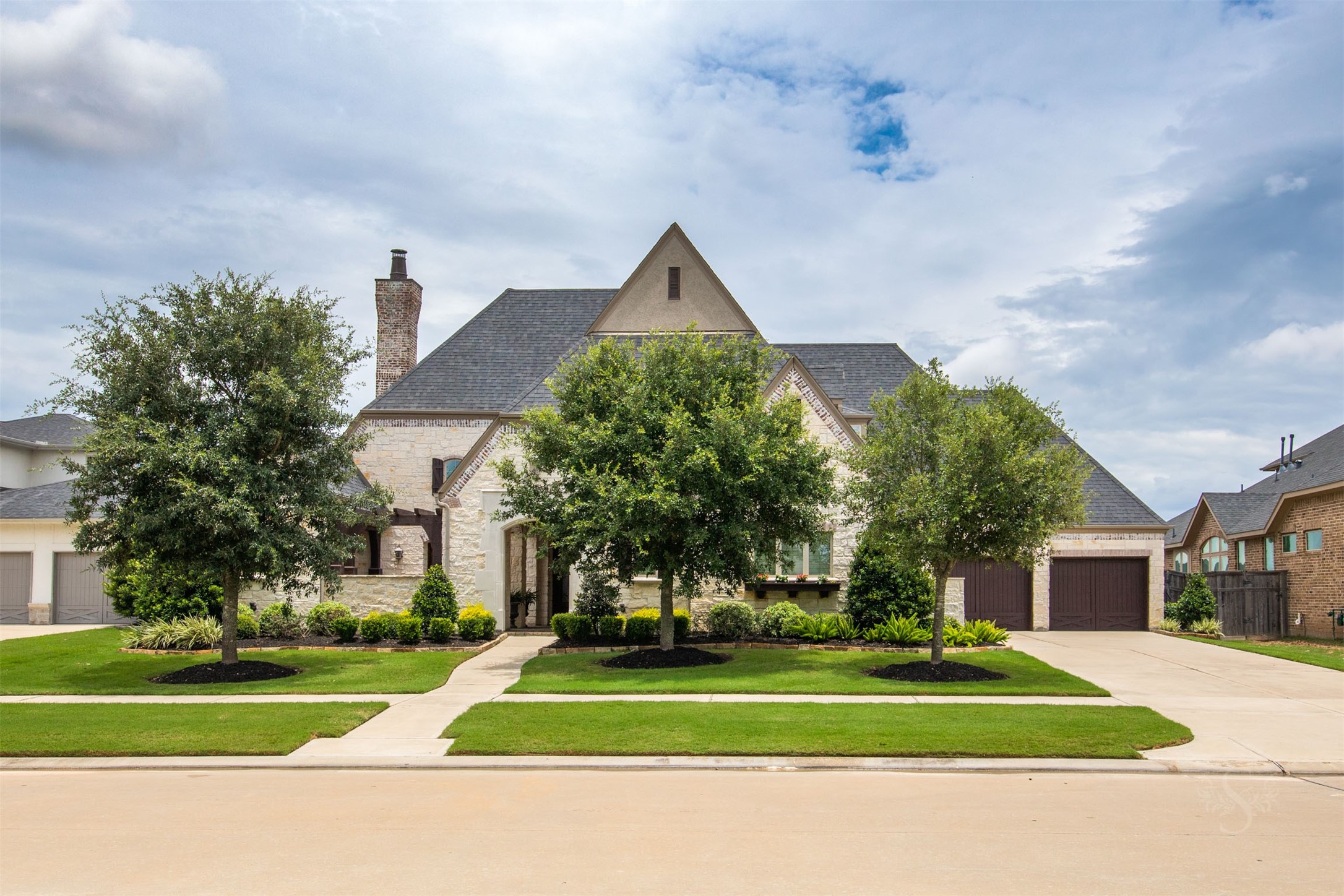28602 Hoffman Spring Lane Fulshear, TX 77441 - Photo 49 of 50 Spectacular 2 story Huntington home set on an expansive greenbelt lot, offering 5,513 square feet, 5 bedrooms (2 down), 5 full and 3 half baths, and a rare 4-car garage. From the moment you arrive, the timeless stone façade, manicured landscape, and private courtyard entry create a striking first impression of the scale and architectural presence found throughout.