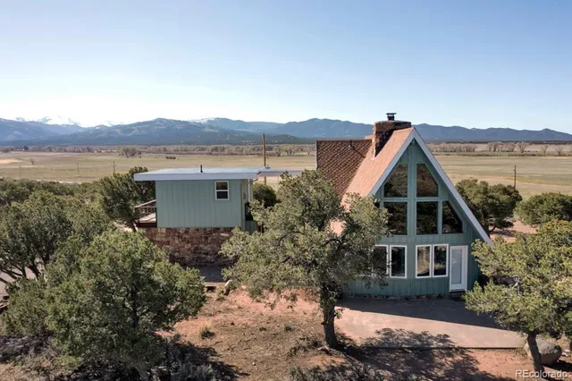 a front view of a house with a yard and lake view