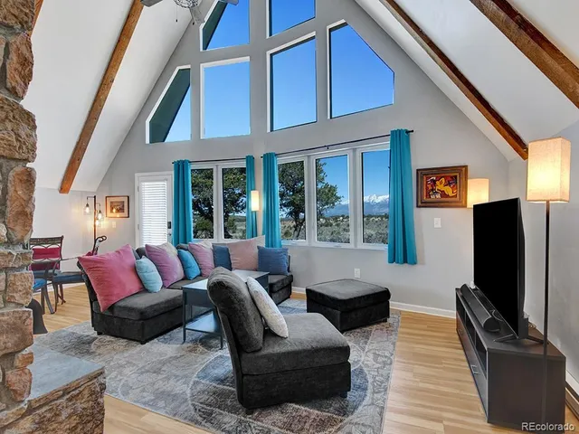 a living room with furniture ceiling fan and a floor to ceiling window