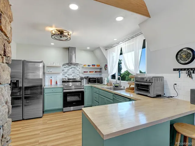 a kitchen with kitchen island a stove and a wooden floors