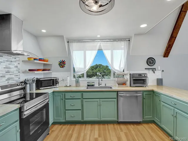 a kitchen with stainless steel appliances a sink a stove and cabinets