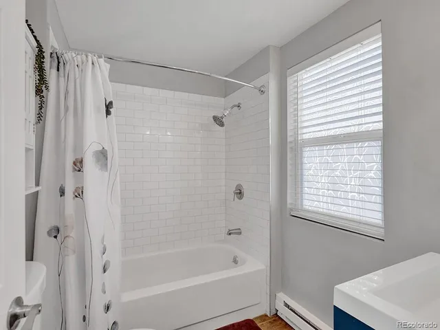 a bathroom with a bathtub a shower and a window