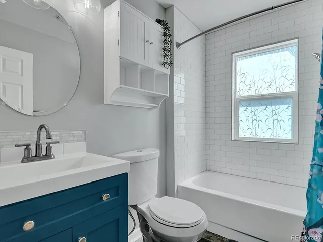 a bathroom with a sink a toilet a mirror and shower