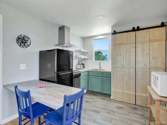 a kitchen with a sink and a stove with wooden floor
