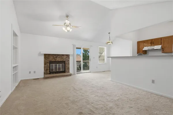 an empty room with windows and fireplace