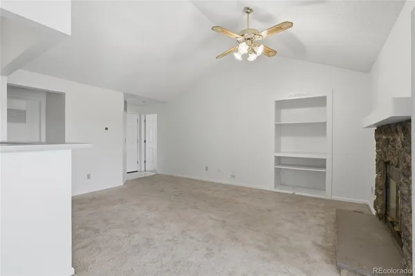 a view of an empty room with a ceiling fan