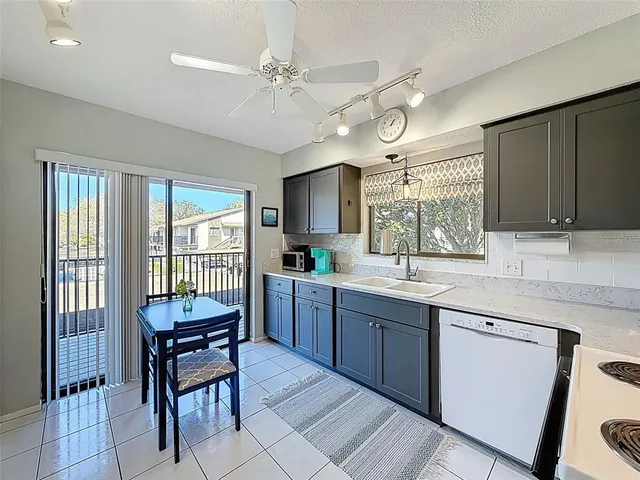 a kitchen with granite countertop a sink cabinets and stainless steel appliances