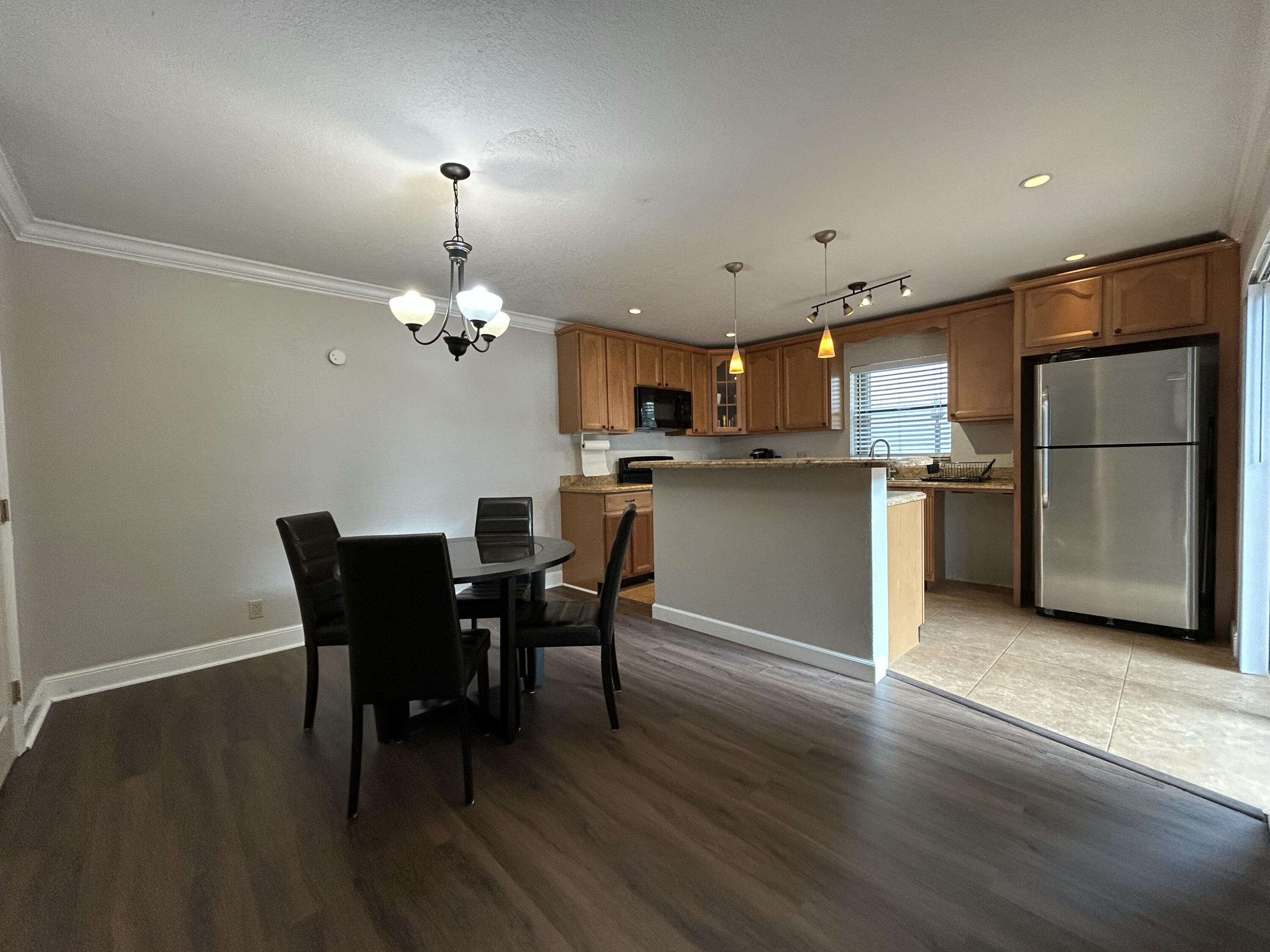 1251 South Federal Highway, Unit 1160 Boca Raton, FL 33432 - Photo 21 of 21 a kitchen with kitchen island a dining table chairs stainless steel appliances and cabinets