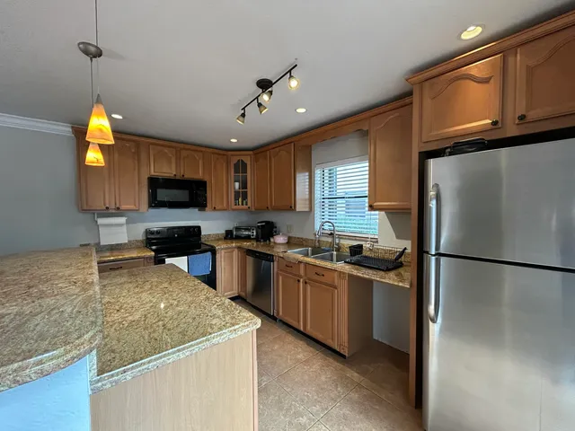 a view of a dining room and livingroom with furniture wooden floor a rug a potted plant and a chandelier