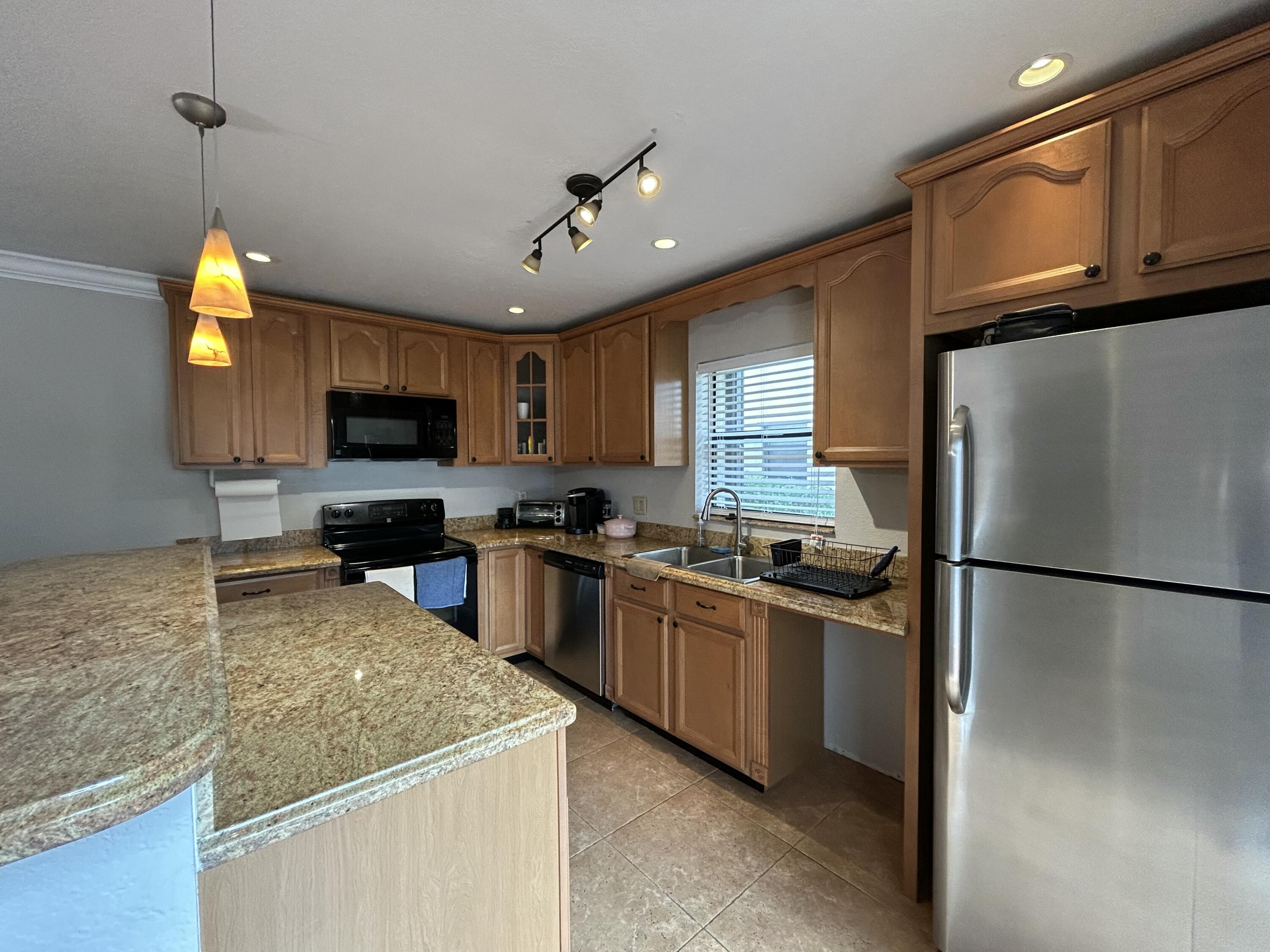1251 South Federal Highway, Unit 1160 Boca Raton, FL 33432 - Photo 6 of 21 a kitchen with kitchen island granite countertop stainless steel appliances and a sink
