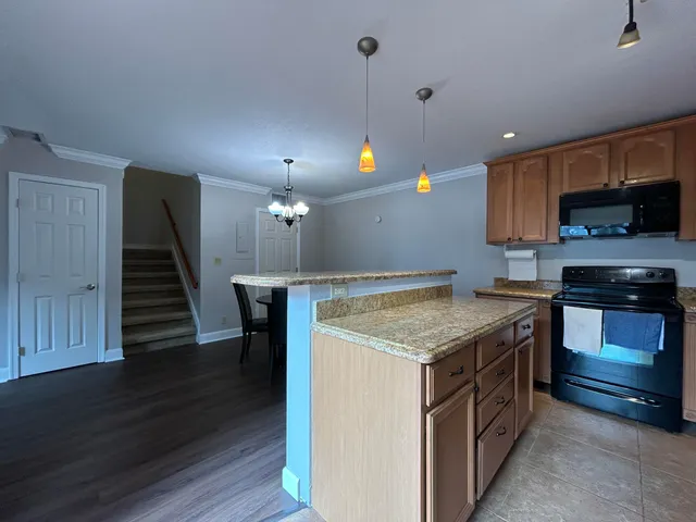 a kitchen with kitchen island granite countertop stainless steel appliances and a sink
