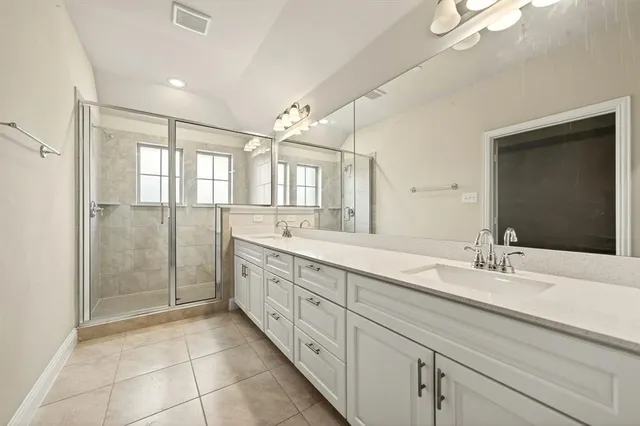 a spacious bathroom with a double vanity sink mirror and shower