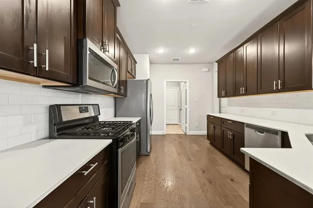 a kitchen with granite countertop stainless steel appliances and wooden cabinets