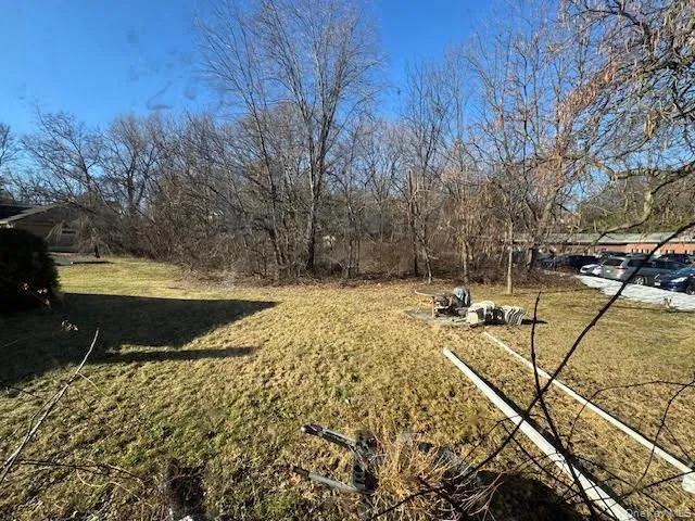 a view of a yard with wooden fence