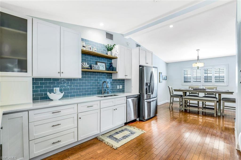 739 7th Avenue North Naples, FL 34102 - Photo 11 of 30 a kitchen with stainless steel appliances a stove a sink a refrigerator cabinets and wooden floor