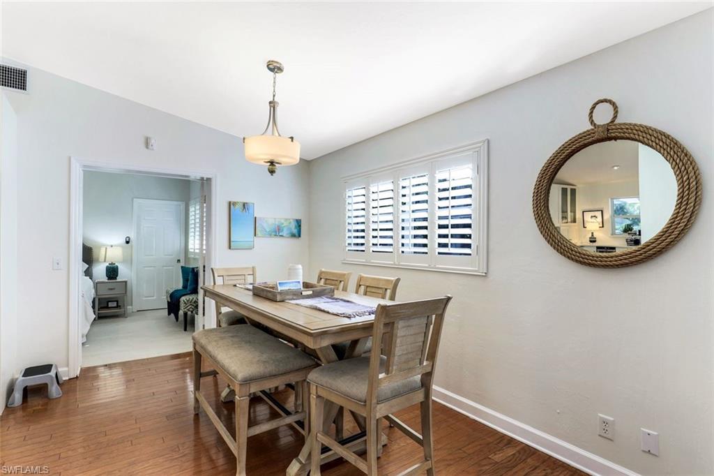 739 7th Avenue North Naples, FL 34102 - Photo 13 of 30 a dining room with wooden floor a chandelier