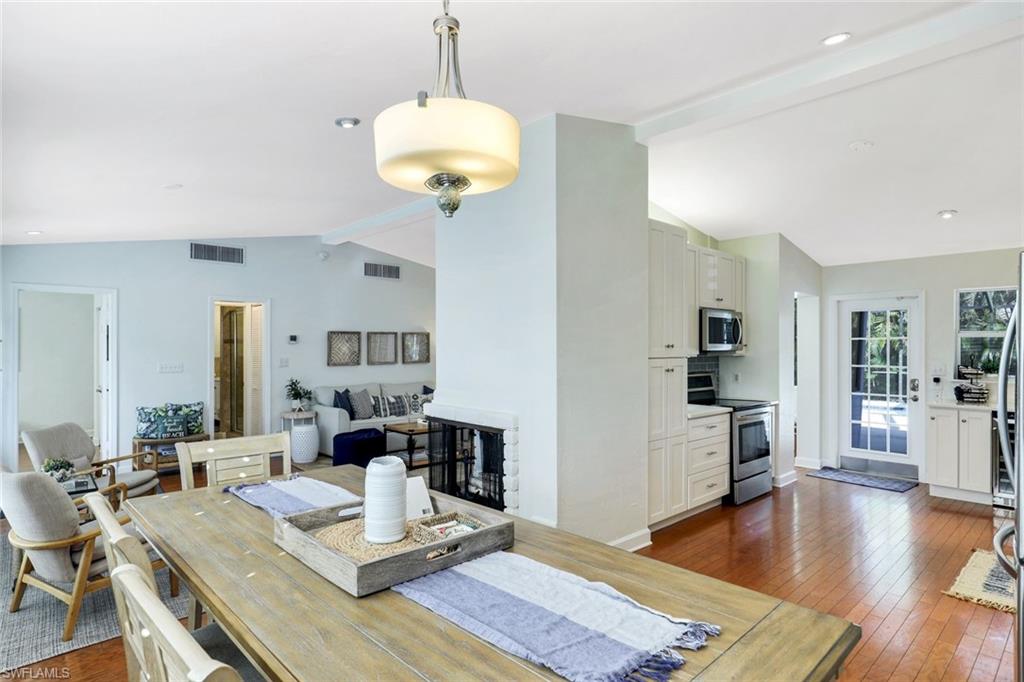 739 7th Avenue North Naples, FL 34102 - Photo 15 of 30 a view of a dining room and livingroom with furniture wooden floor a chandelier