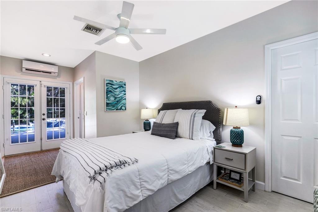 739 7th Avenue North Naples, FL 34102 - Photo 25 of 30 a bedroom with a bed a chandelier and a window